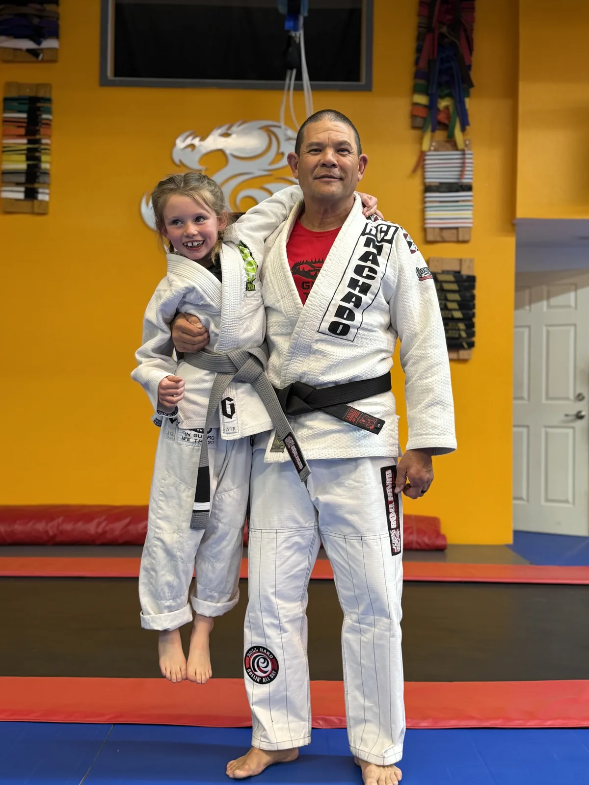 Owner George Fujii carrying a young student, a genuine moment at West Coast Martial Arts