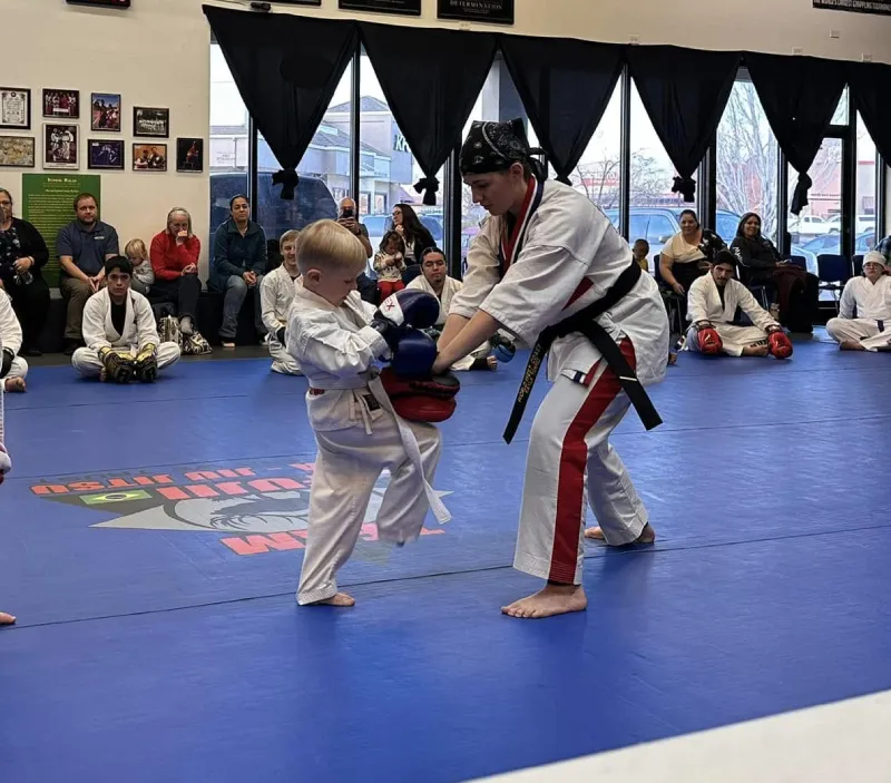 Coach guiding child in martial arts class